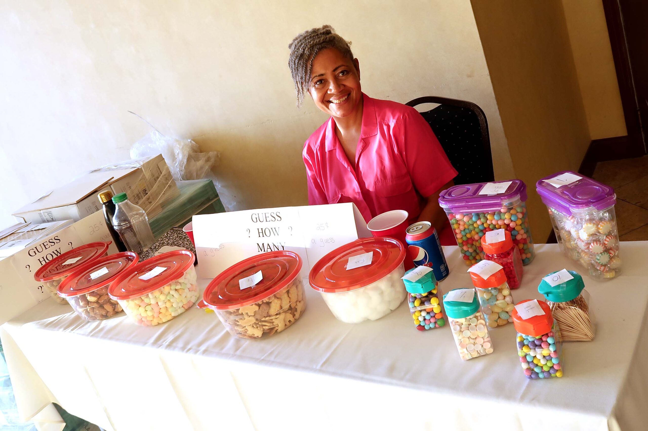 There was a guessing game table at the entrance to the Johnson-Barnes Family Reunion Meet and Greet. Liz Osborne overseeing containers of peanuts, M&Ms, toothpicks, cotton balls, and other items. Members wrote their guess(s) of numbers in each container and closest to correct numbers won. Winners were announced at the banquet and prizes were the containers